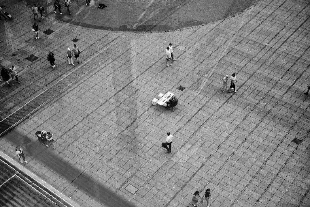 Aerial view of an anonymous crowd of people walking across a plaza